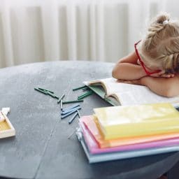 Tired little girl taking a nap at her desk.
