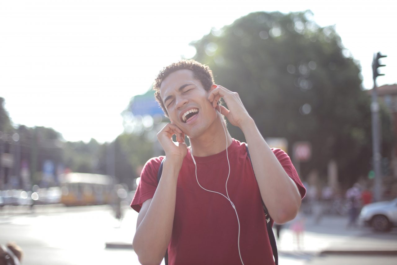 Young man listening to music through headphones.