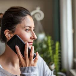 Woman with hearing aid talking on the phone.