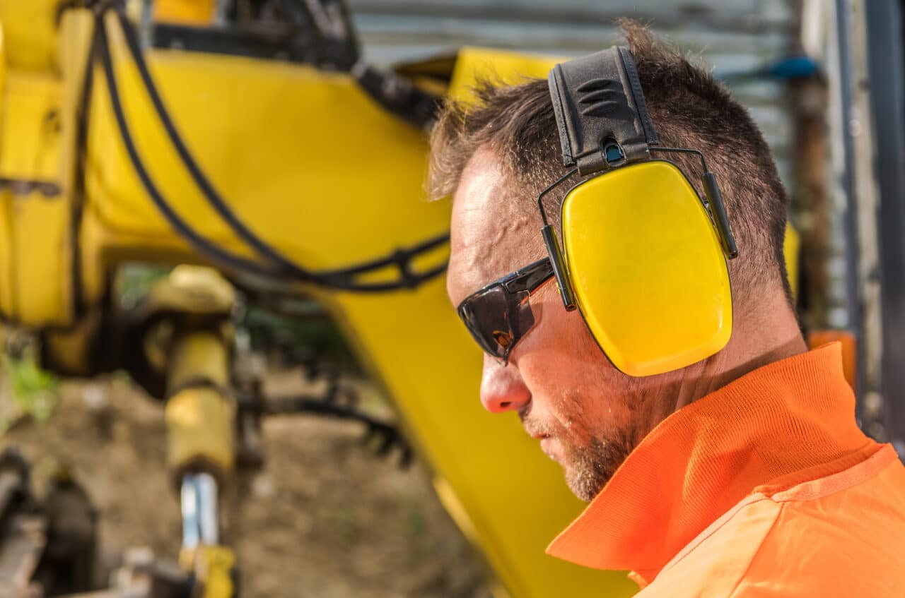 Man wearing earmuffs to protect his ears on a construction site.