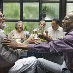 A group of older friends enjoying a dinner party together.