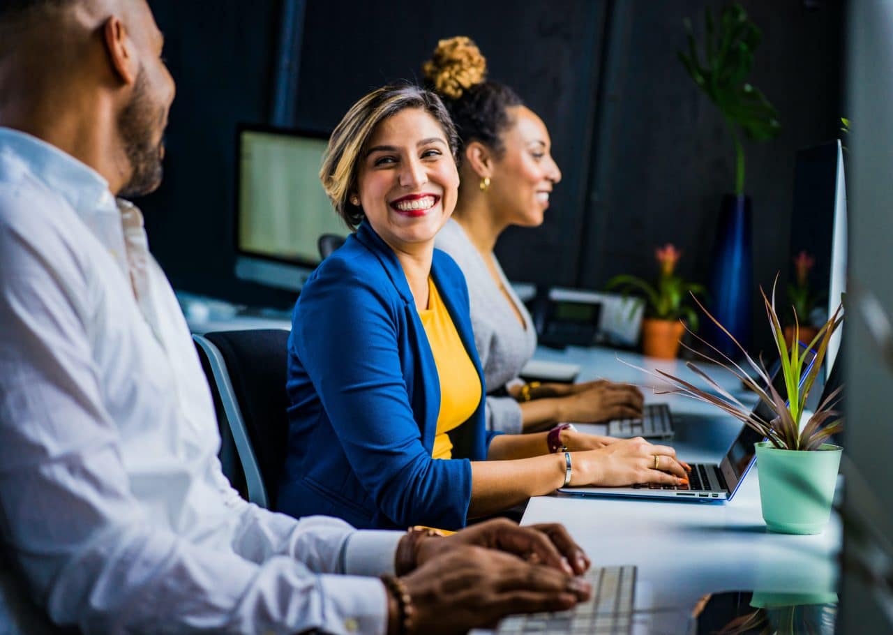 Woman smiling and chatting with her coworkers.