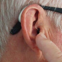 Man adjusting his hearing aid.