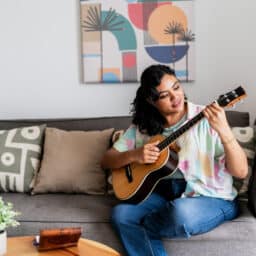 Woman playing her guitar at home