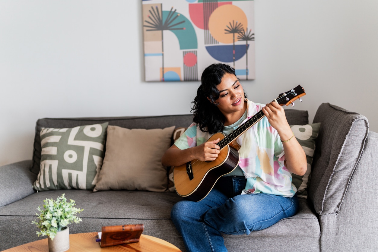 Woman playing her guitar at home.