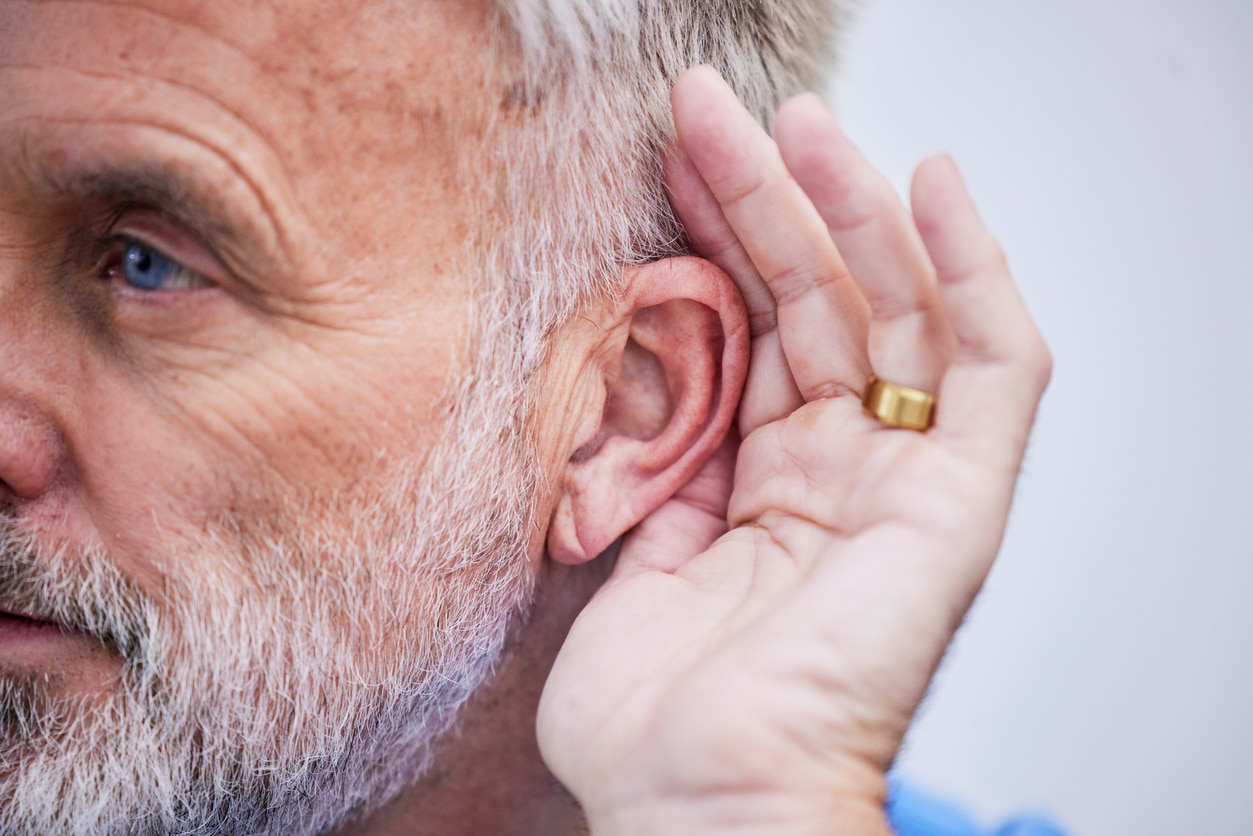 Man cups ear to indicate hearing loss