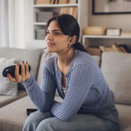 Teen with a hearing aid watching tv.