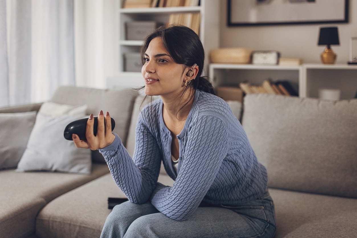 Teen with a hearing aid watching tv.