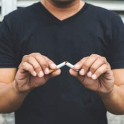 Man breaking a cigarette in half