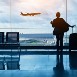 Woman in the airport watching a plane fly by