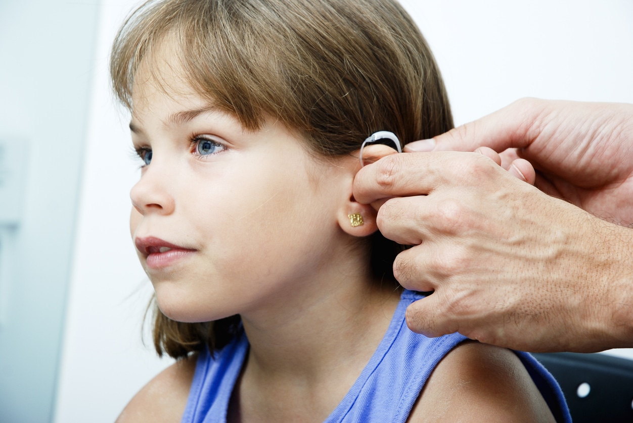 Young girl getting a new hearing aid.