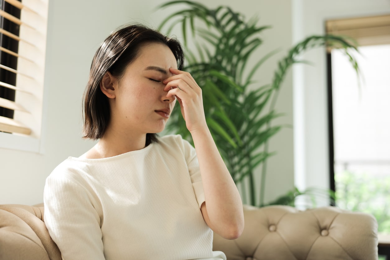 Tired woman holding her nose bridge